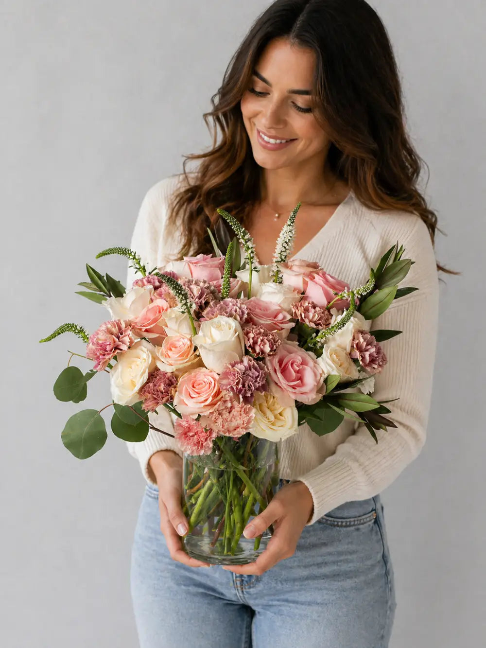 Woman holding a bouquet of flowers against a gray background