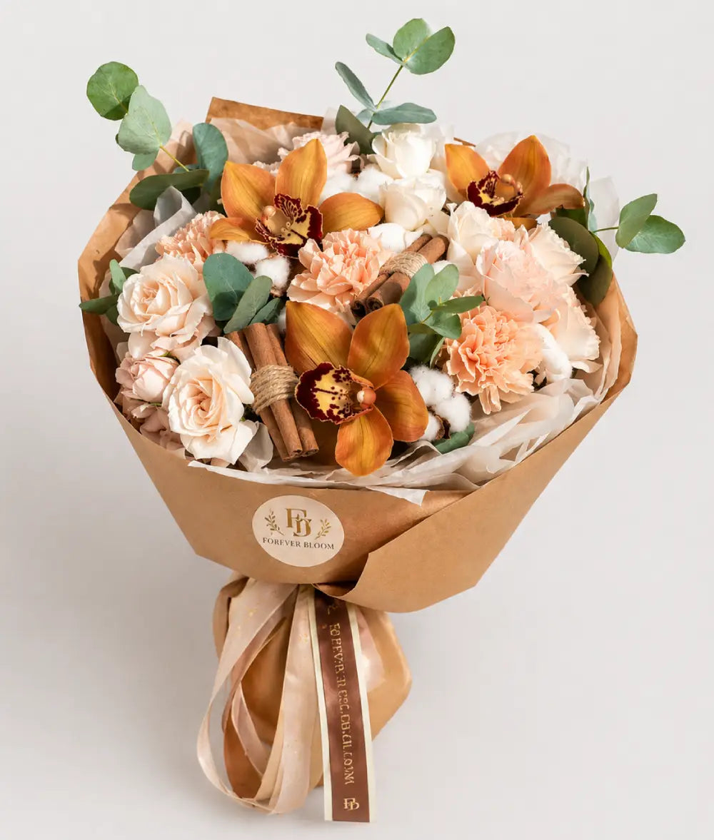 Bouquet of flowers wrapped in brown paper with a visible brand logo on a light background