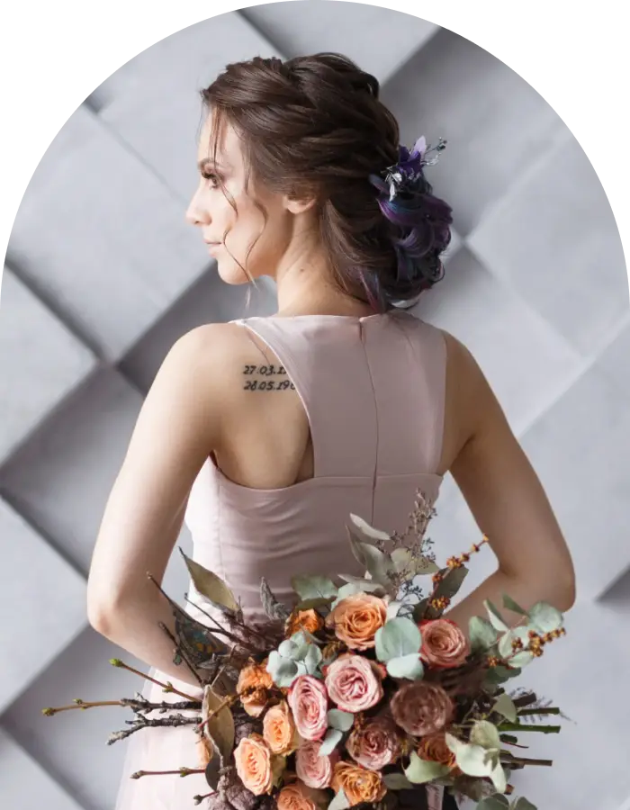 Woman holding a bouquet of flowers with a neutral background