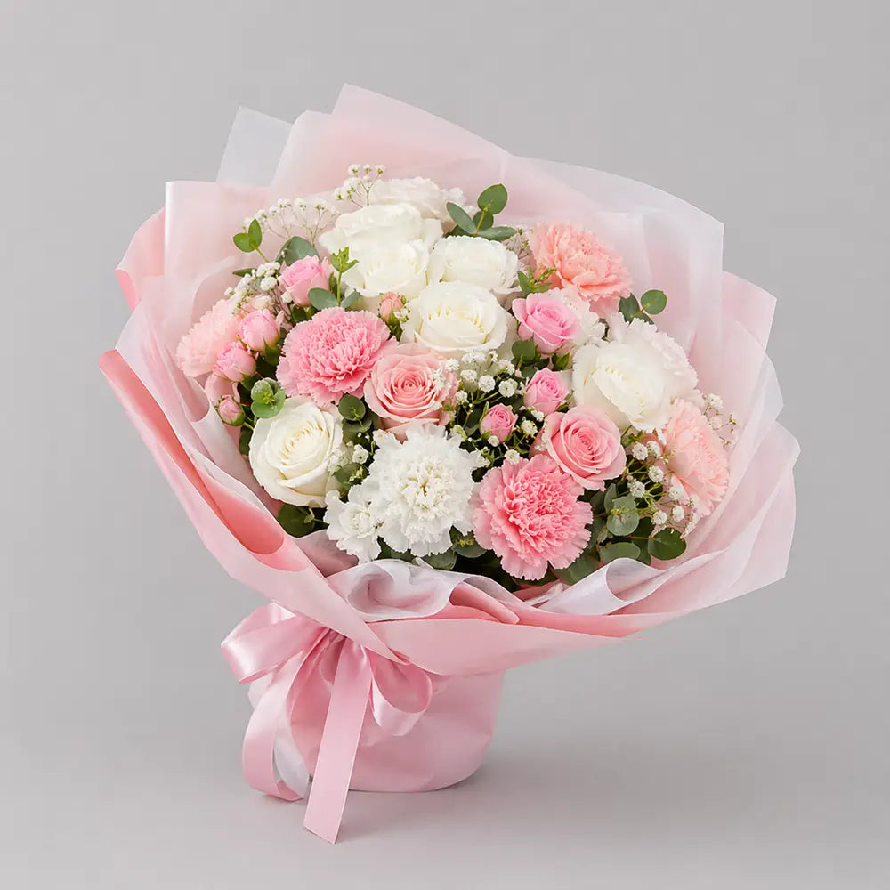 Bouquet of pink and white flowers wrapped in pink paper on a gray background