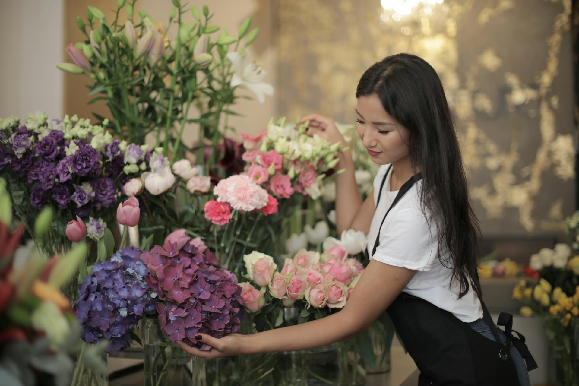 Woman arranging flowers in a floral shop with a blurred background