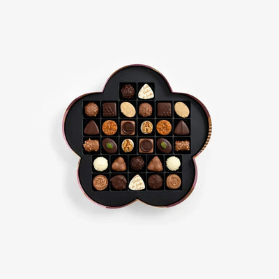 Decorative box filled with assorted chocolates on a white background