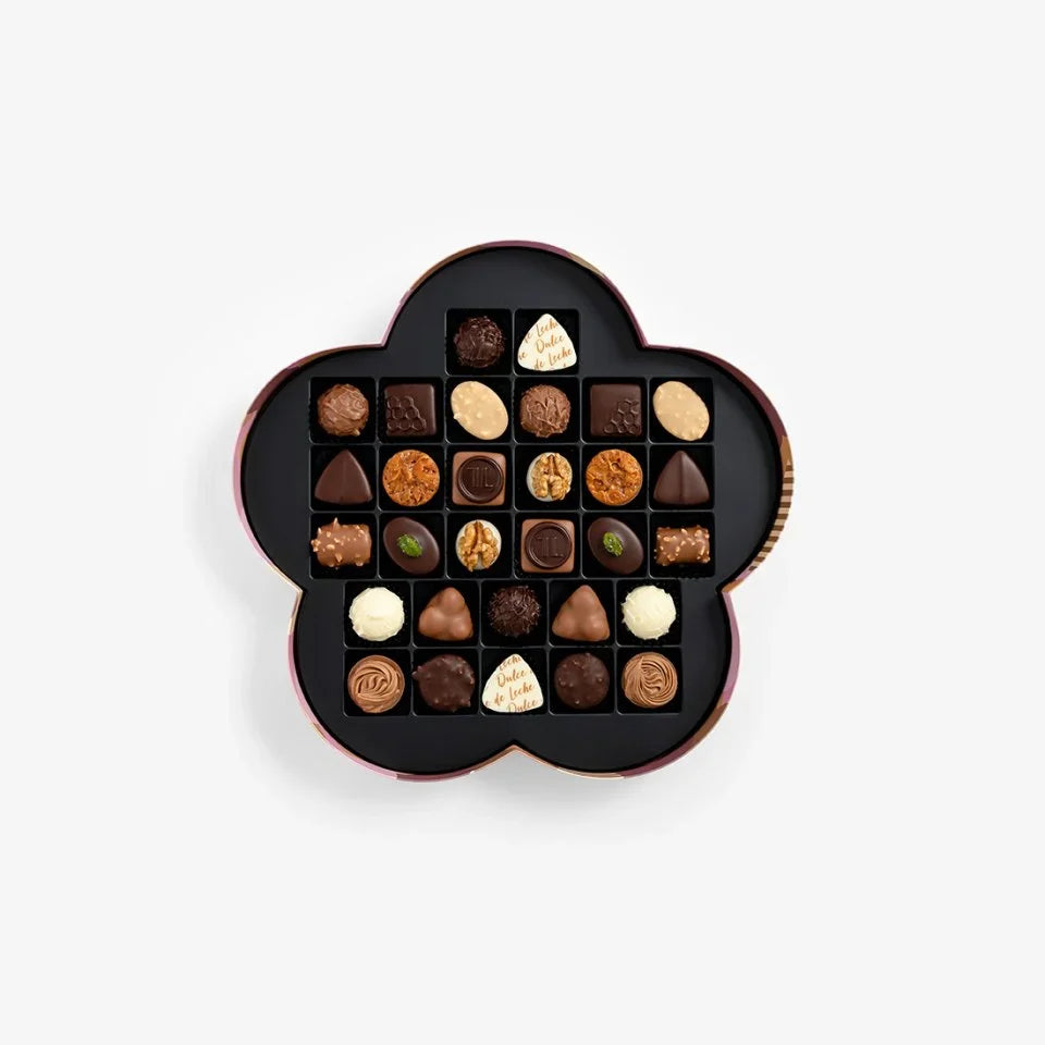 Decorative box filled with assorted chocolates on a white background