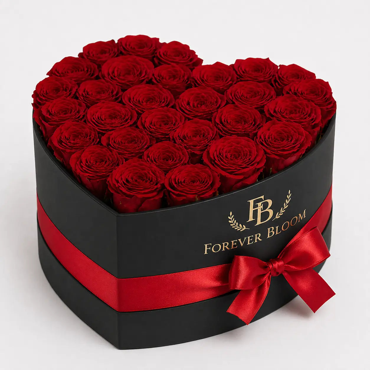 Heart-shaped box of red roses with a red ribbon and 'Forever Bloom' branding on a white background