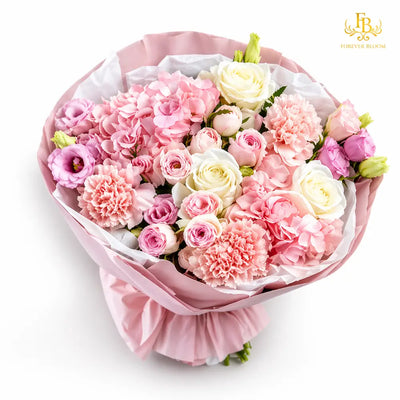 Bouquet of pink and white flowers wrapped in pink paper on a white background
