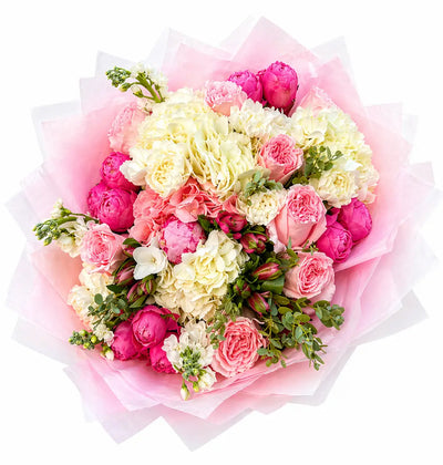 Bouquet of pink and white flowers with greenery on a white background