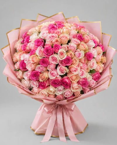 Bouquet of pink and white roses with a pink ribbon on a gray background