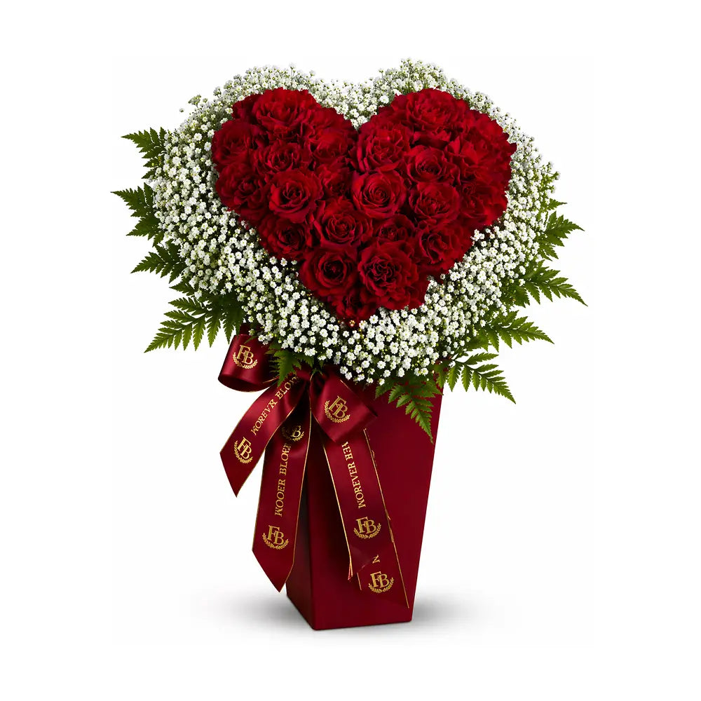 Heart-shaped bouquet of red roses with a red box and ribbon on a white background