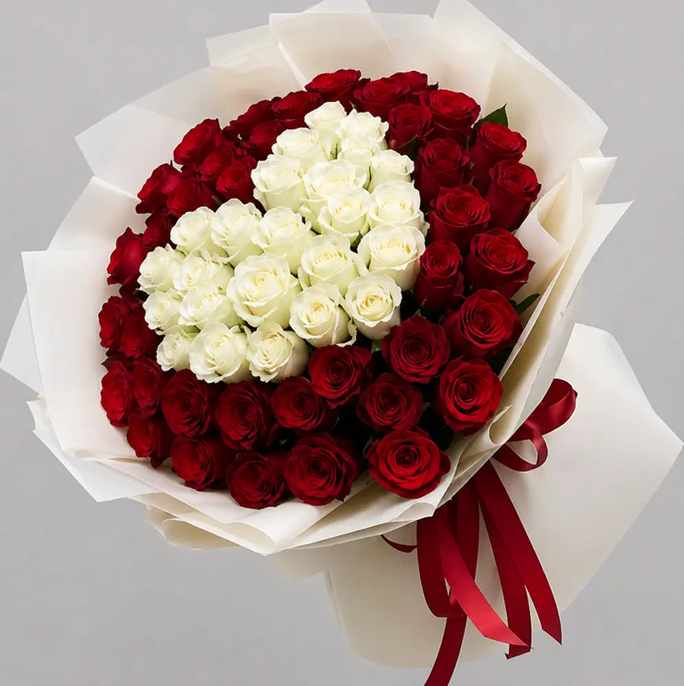 Bouquet of red and white roses with a heart shape on a gray background