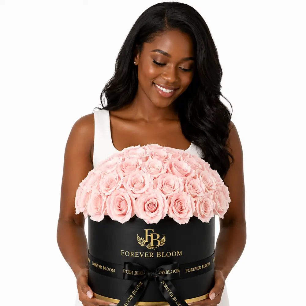 Woman holding a large bouquet of pink roses in a black box with 'Forever Bloom' branding.