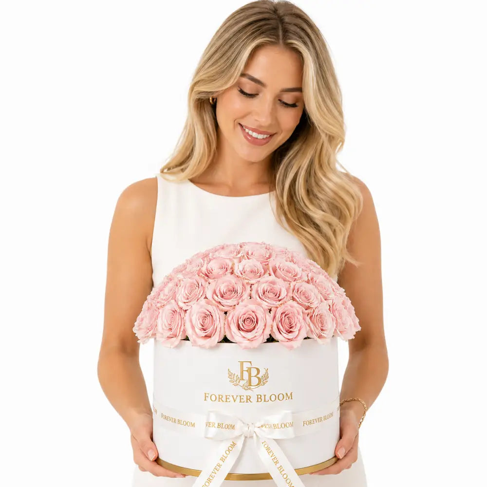 Woman holding a white box with pink roses labeled 'Forever Bloom' on a white background