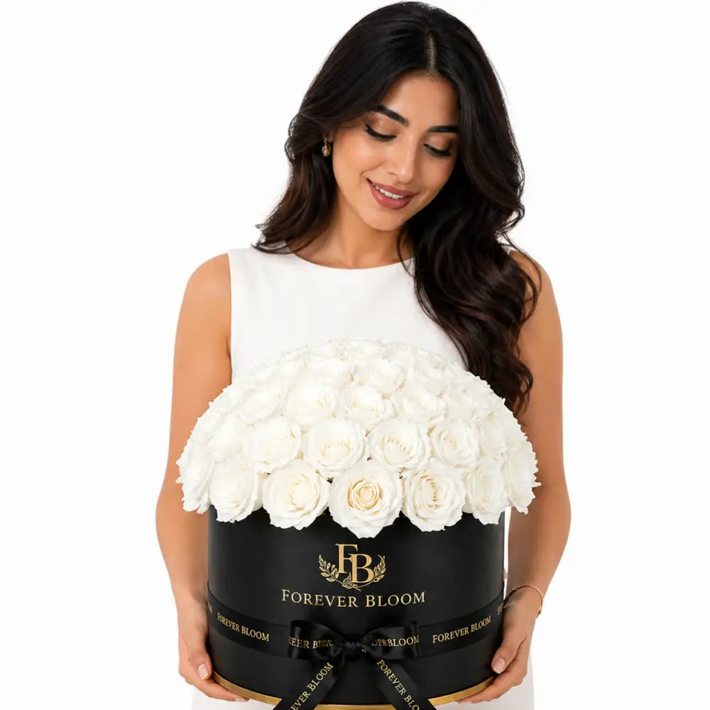 Woman holding a large black box of white flowers with 'Forever Bloom' branding.