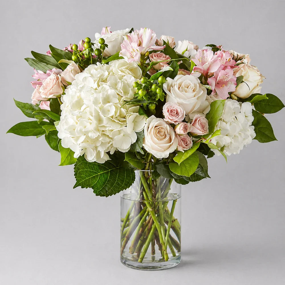 Bouquet of flowers in a clear vase on a gray background