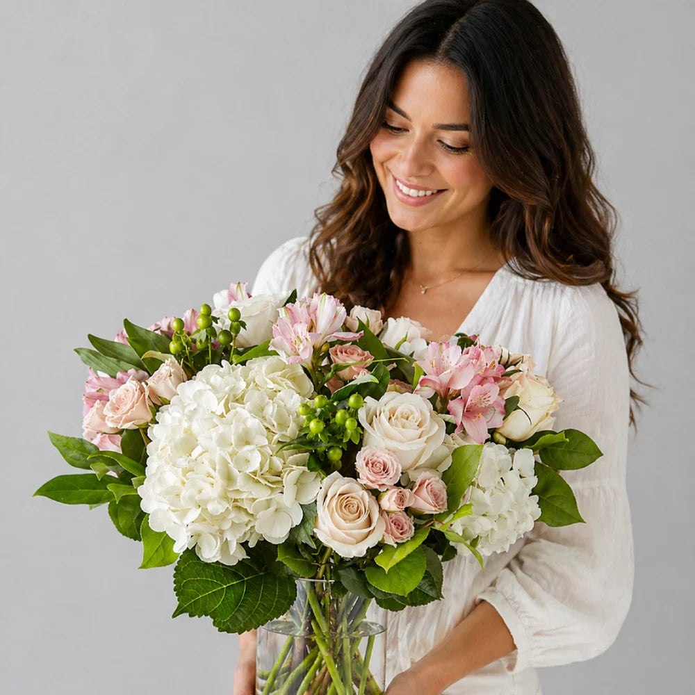 Woman holding a bouquet of flowers against a gray background