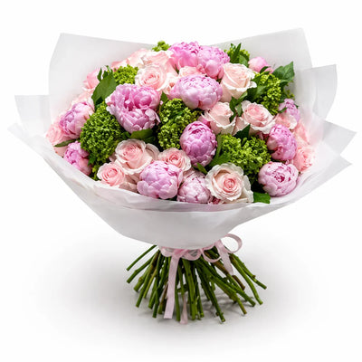 Bouquet of pink and green flowers wrapped in white paper on a white background