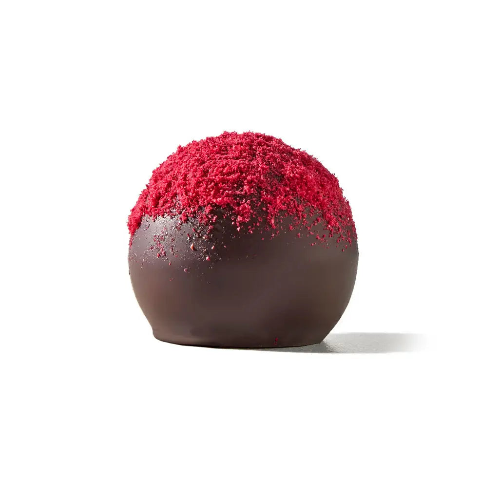 Chocolate truffle with red powder on a white background