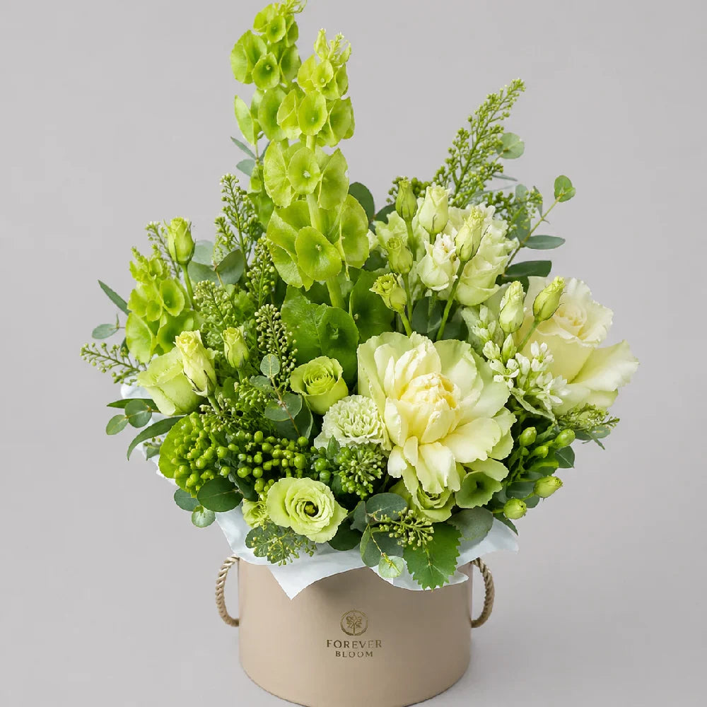 Bouquet of green and yellow flowers in a beige container on a gray background