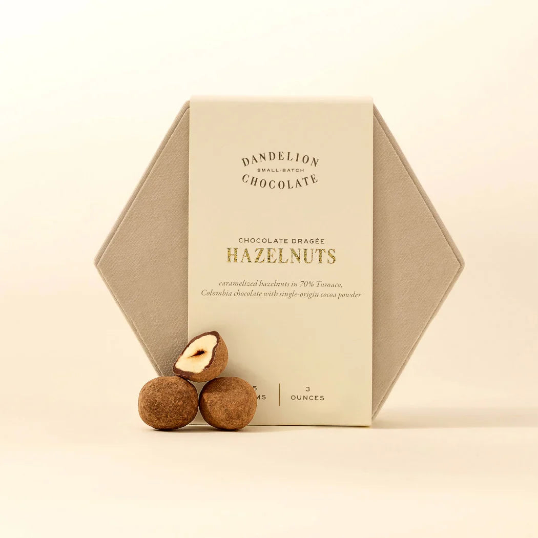 Hexagonal box of Dandelion Chocolate Hazelnuts on a beige background
