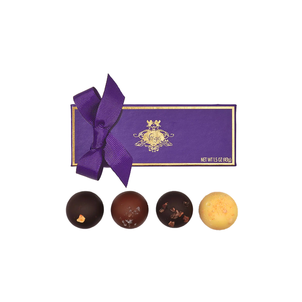 Purple chocolate box with a bow, surrounded by four assorted chocolates on a white background
